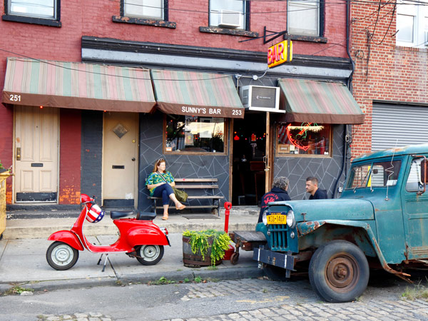 a woman sitting outside Sunny's Bar, Red Hook, NYC