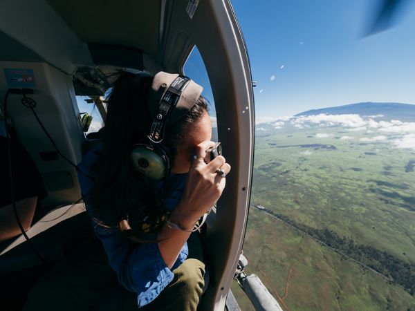 a person riding a helicopter above Hawai‘i Island