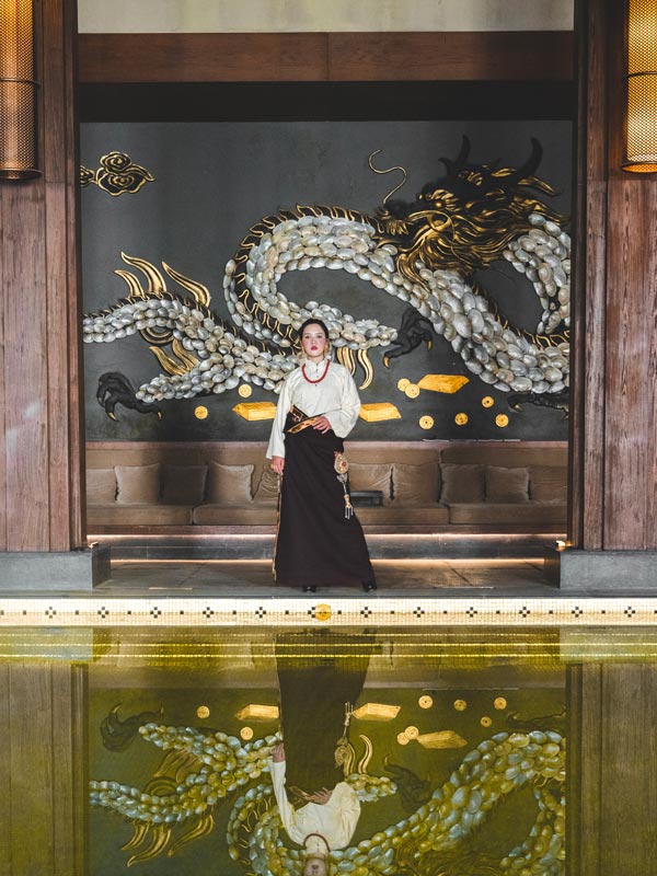 a woman standing on the side of the pool at St Regis Lhasa Pool
