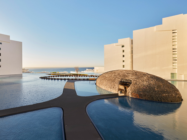 an expansive pool surrounded by white structures at Viceroy Los Cabos