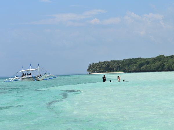 tourists swimming in the shallow waters of Balabac, Palawan, Philippines