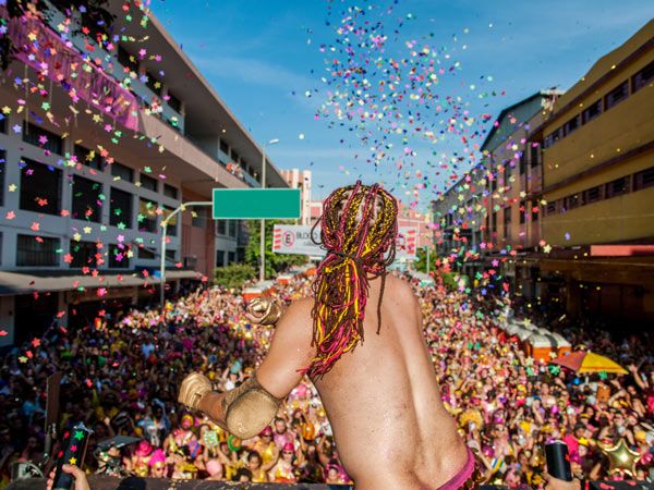 a performer throwing colourful confettis at Carnaval in Brazil