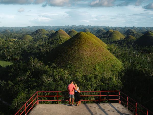 a couple admiring the landscape at Chocolate Hills, Bohol, Philippines