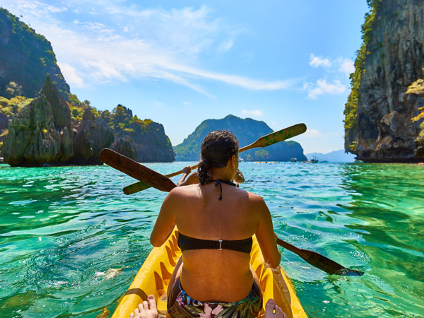 a woman kayaking in El Nido, Palawan, Philippines