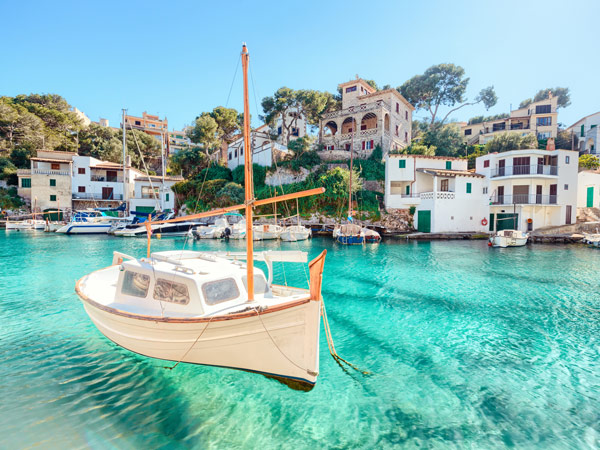 a small yacht navigating the turquoise-coloured waters of Mallorca