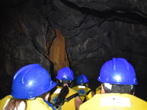 a group of tourists wearing safety helmets and life jackets inside Puerto Princesa Underground River