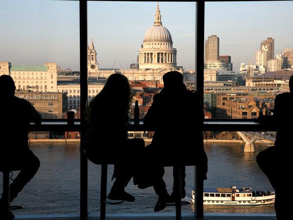 a couple sitting in front of the panoramic London skyline at The Tate Modern