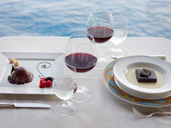 a plate of Chocolate Lasagna Zabaione with wine glasses on the side
