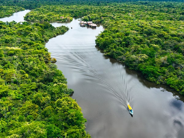 an aerial view of a ship cruising along the Amazon River