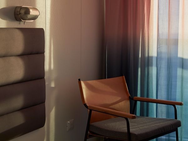 a chair beside the curtains at sea terrace cabin, Virgin Voyages’ Resilient Lady