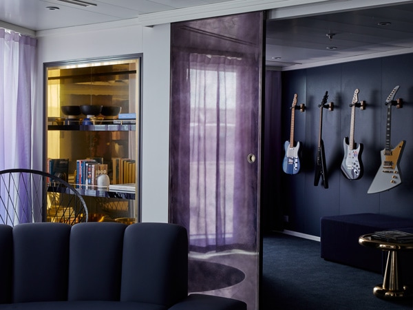 a media room stocked with four guitars at the massive suite, Virgin Voyages’ Resilient Lady
