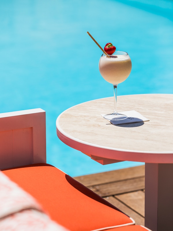 a cocktail drink on the table by the poolside bar at Hôtel La Tartane
