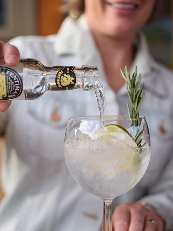 a bartender pouring gin and tonic into the glass at Park Distillery