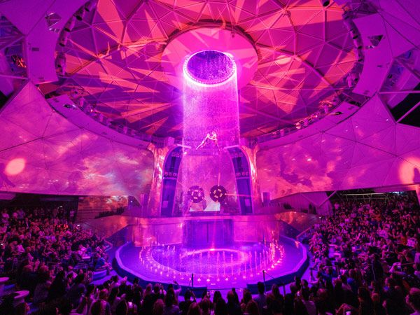 the tallest waterfall at sea lighted in pink at AquaDome, Icon of the Seas