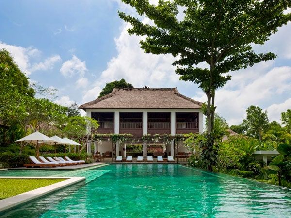 a jade green pool with sun lounges at COMO Uma Ubud