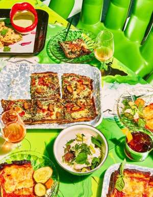 a wide selection of dishes on the green table at Shuggie’s Trash Pie and Natural Wine Bar
