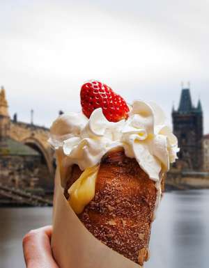 a hand holding Trdelník in Prague