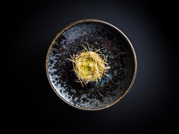 a plate of leek tart on black background, Atelier Crenn, San Francisco
