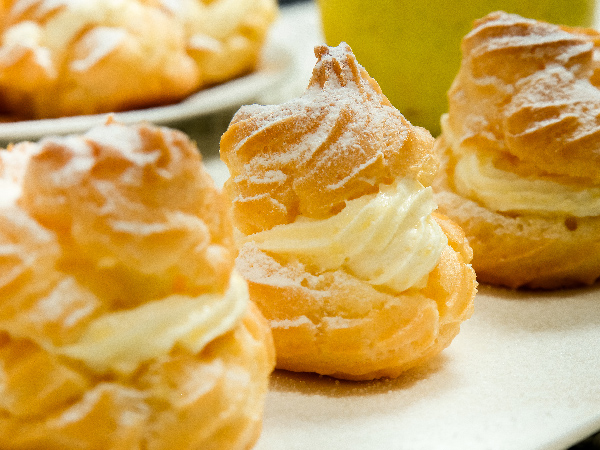 Close up of a cream puff on a white table. Selective focus
