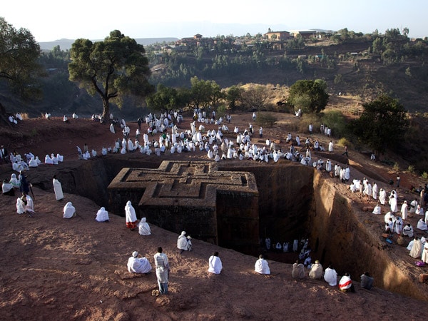 worshipers gathering around rock-hewn monolithic church, Lalibela, Ethiopia