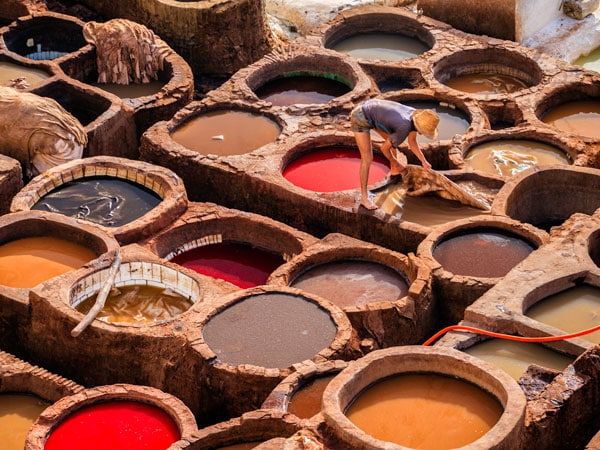 a man working in traditional Moroccan leather tanneries in Fes, Morocco