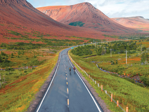 Gros Morne road with a red landscape in the background
