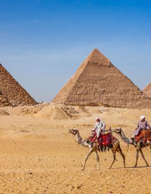 Bedouins riding on camels at The Great Pyramid of Giza in Egypt