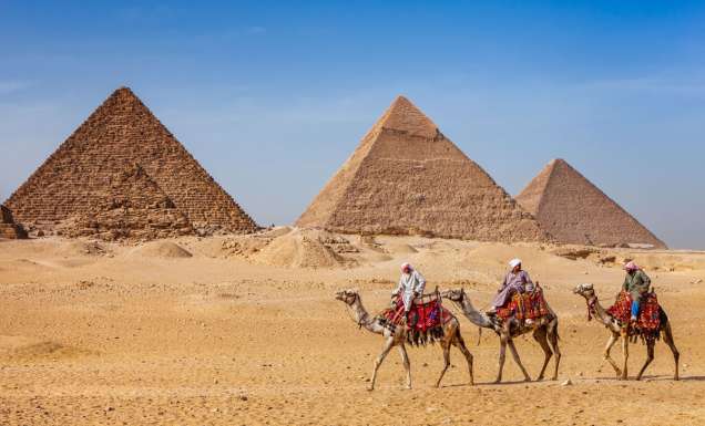 Bedouins riding on camels at The Great Pyramid of Giza in Egypt