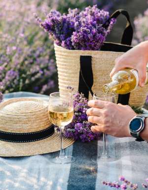 pouring some Provence wine into a glass on the lavender fields