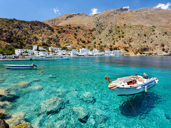 a boat moored on the crystal clear waters in Loutro town on Crete Island