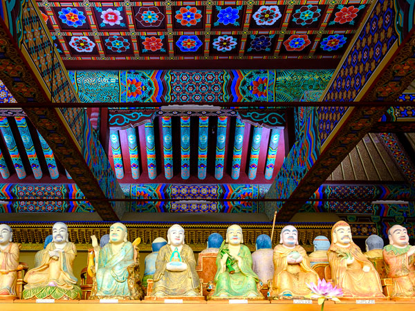 Buddha statues lined in lotus pose at Yakcheonsa Temple on Jeju island, South Korea