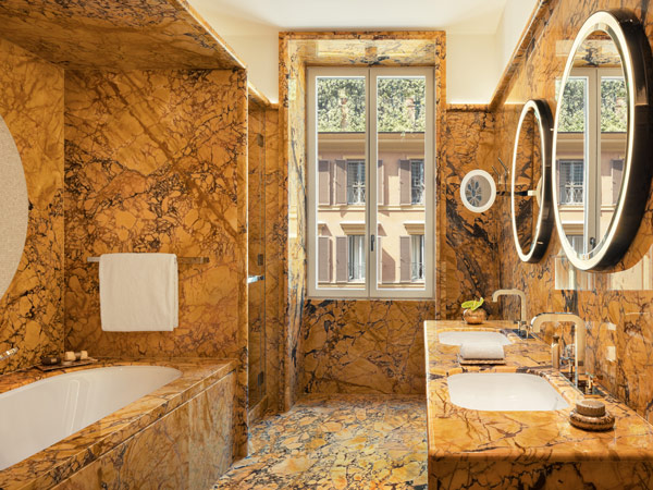 a bathroom with yellow marble windows at Bulgari Roma