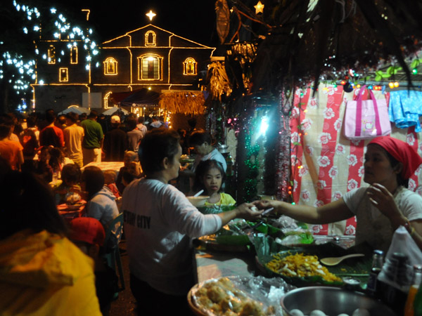 people buying food and Christmas delicacies outside the church after Simbang Gabi in the Philippines