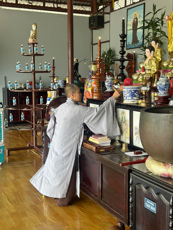 a monk lighting an incense before praying at Linh Quang Pagoda in Vietnam