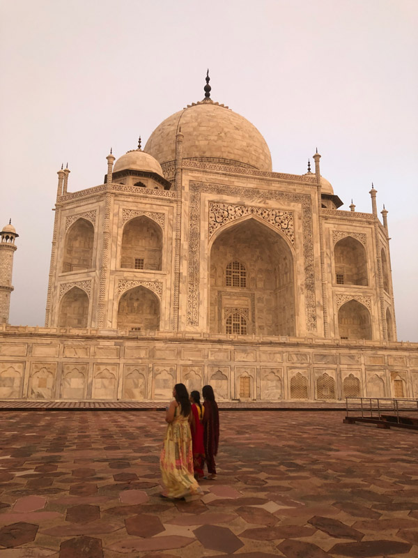 a couple posing behind Taj Mahal in Agra