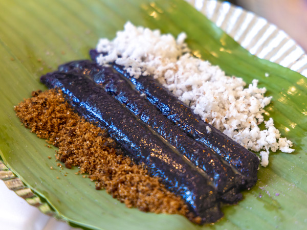 puto bumbong, a Christmas purple rice cake dish on top of a banana leaf