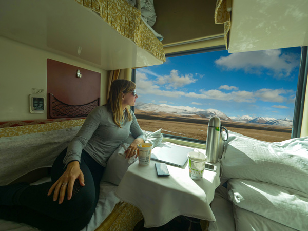 a woman observes Himalaya after eating her cup noodles during train ride