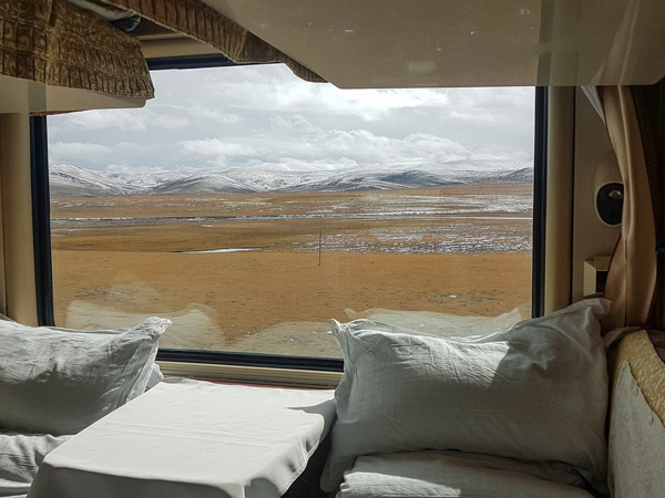 a picturesque view of the snowy Tibetan landscape from a sleeper train
