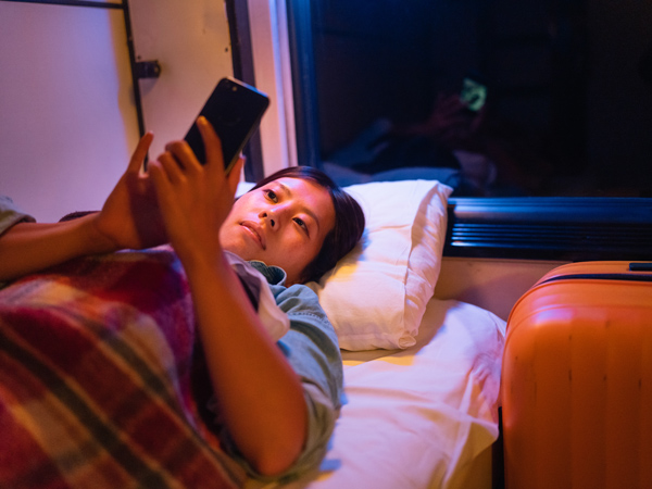a female traveller using a smart phone while traveling at night