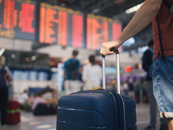 a close-up shot of a person holding his luggage in the airport