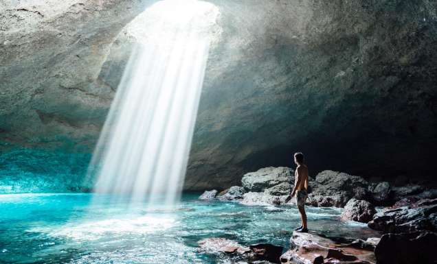 A man inside the Blue Cave on Tanna in Vanuatu