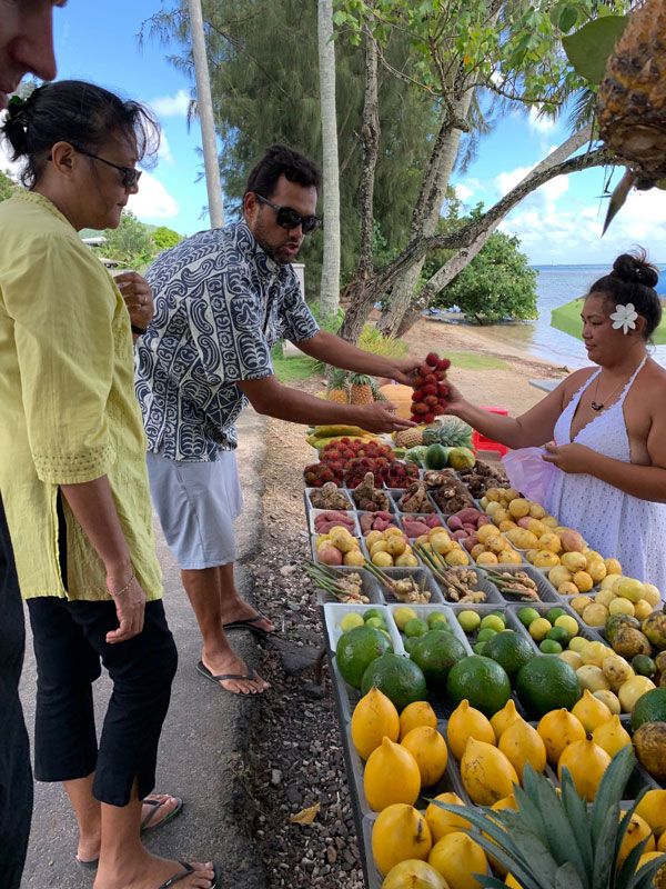 people shopping for fruits at a stall in Moorea Tropical Garden