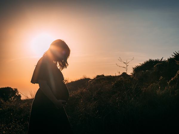 a pregnant woman on sunset background
