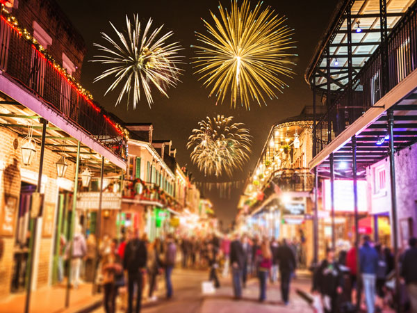 people walking in the street with dazzling fireworks above them in Jackson Square, New Orleans, USA 