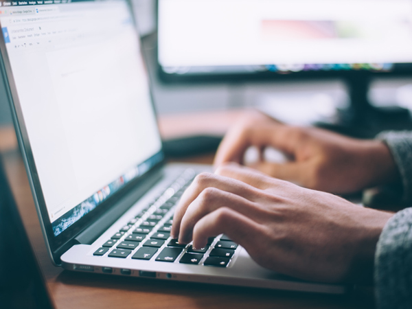 a close-up shot of a hand typing on a laptop keyboard