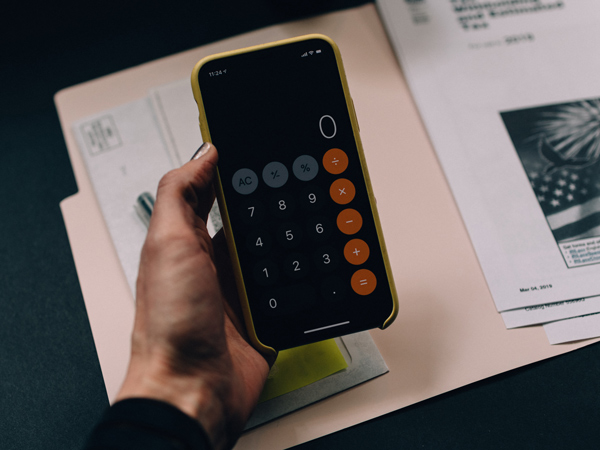 a hand holding a phone calculator