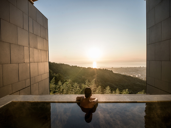 a woman dipping in the pool overlooking the scenic views in ANA InterContinental Beppu