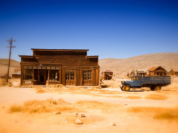 an abandoned building and a rusty car in Bodie, California, USA