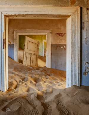 sand dunes covering the floor of an old house in Kolmanskop, Namibia
