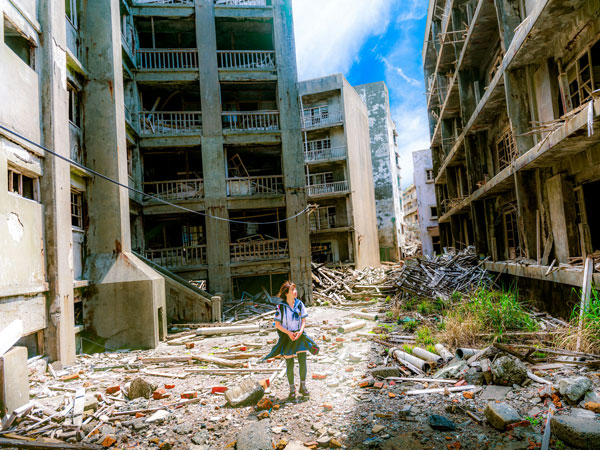 a young woman exploring the abandoned structures around Hashima Island, Japan